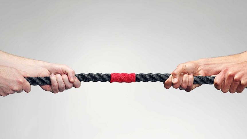 Hands pulling on rope during game of tug-of-war