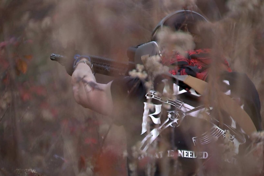 A member of Redneck Revolt aims at a target at a gun range.