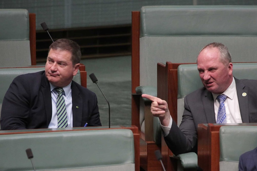 Barnaby Joyce points and scowls while talking with Llew O'Brien in the House of Representatives.
