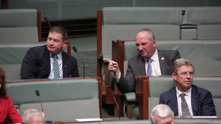 Barnaby Joyce points and scowls while talking with Llew O'Brien in the House of Representatives.