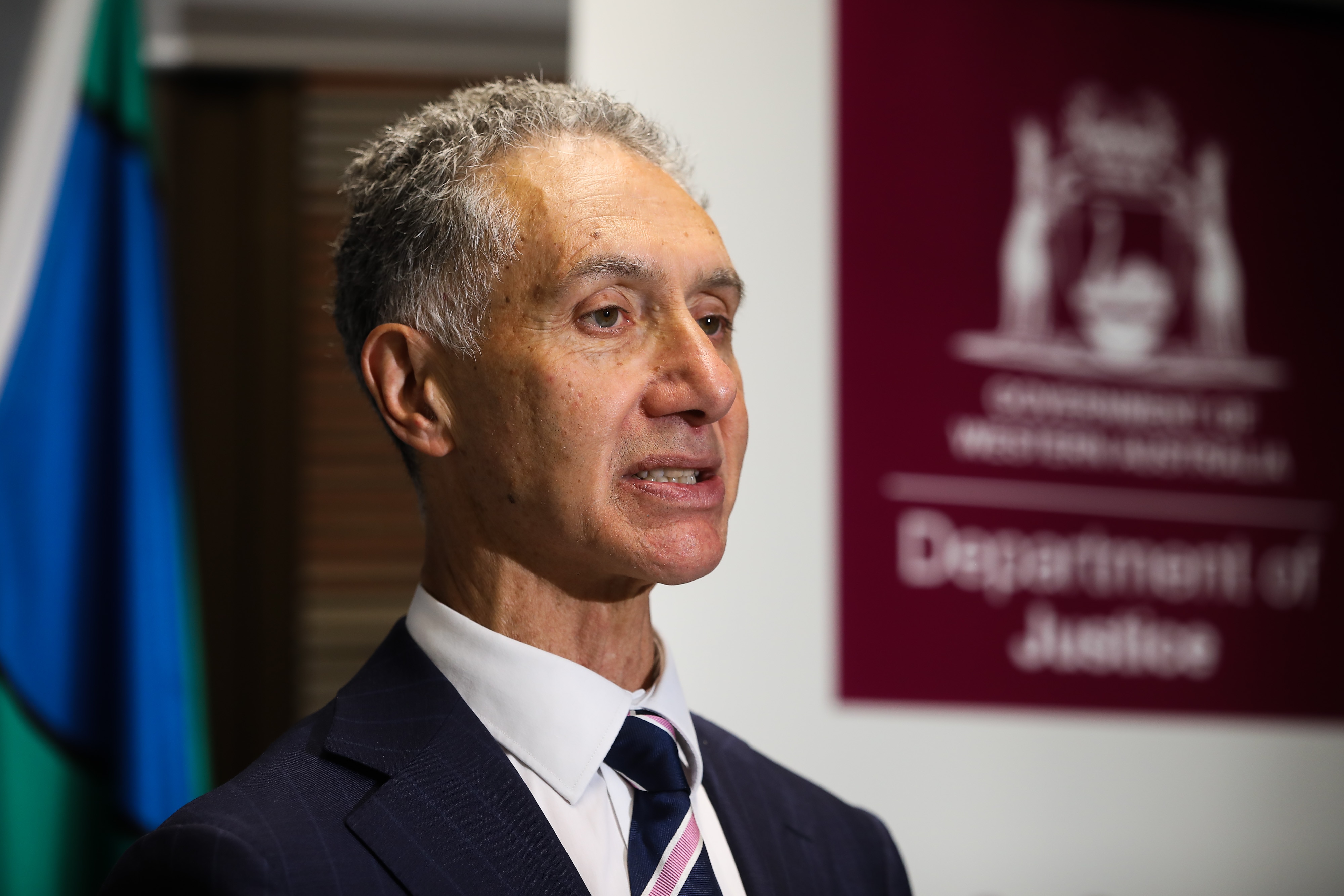 Tony Buti in suit speaks to media.