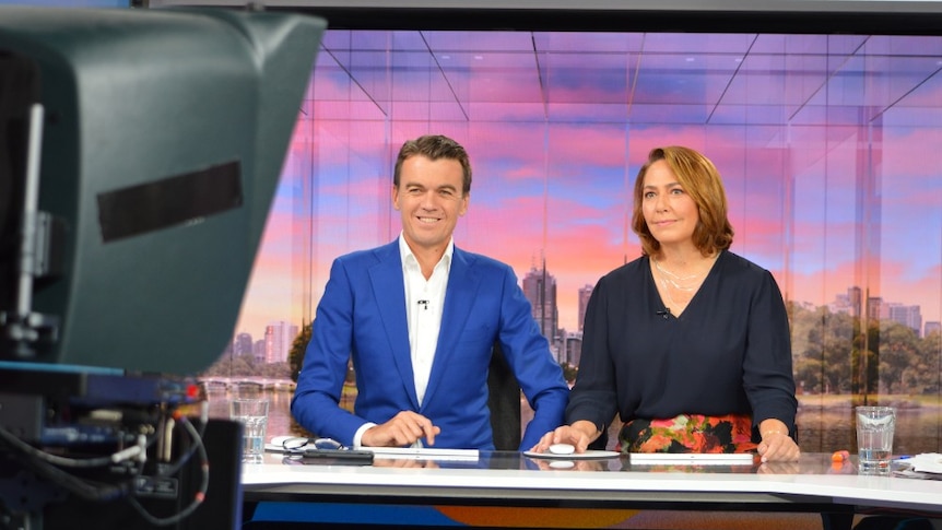 Rowland and Millar sitting at desk in studio looking at camera.