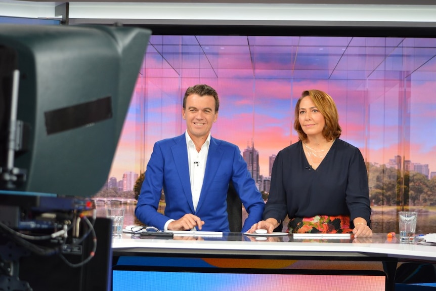 Rowland and Millar sitting at desk in studio looking at camera.