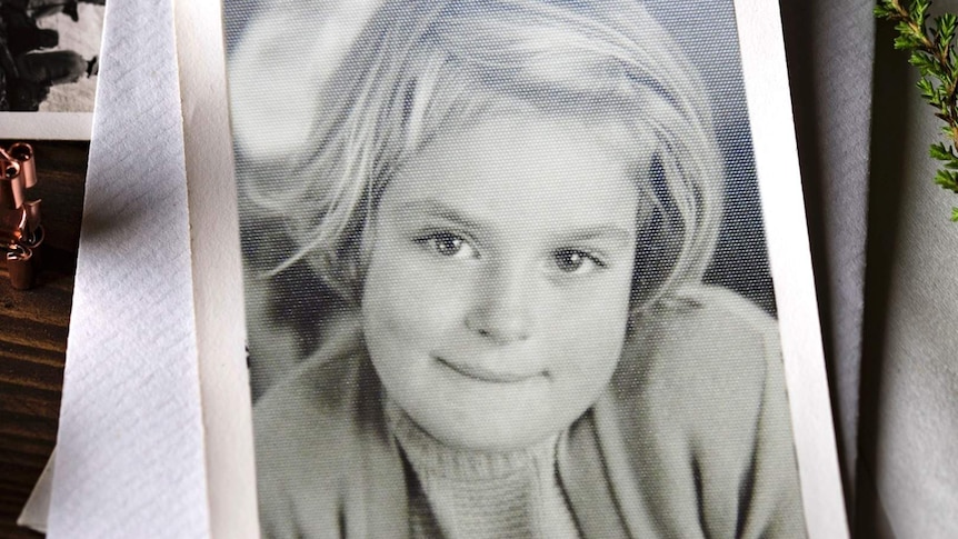 Old black and white picture of a young girl with sandy blonde hair and brown eyes.