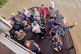 A group of tourists waving on a river cruise in Longreach