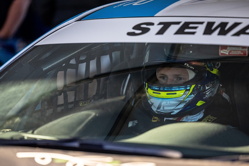 Racing car driving behind wheel with helmet