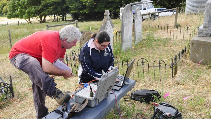 two people at computers in a graveyard