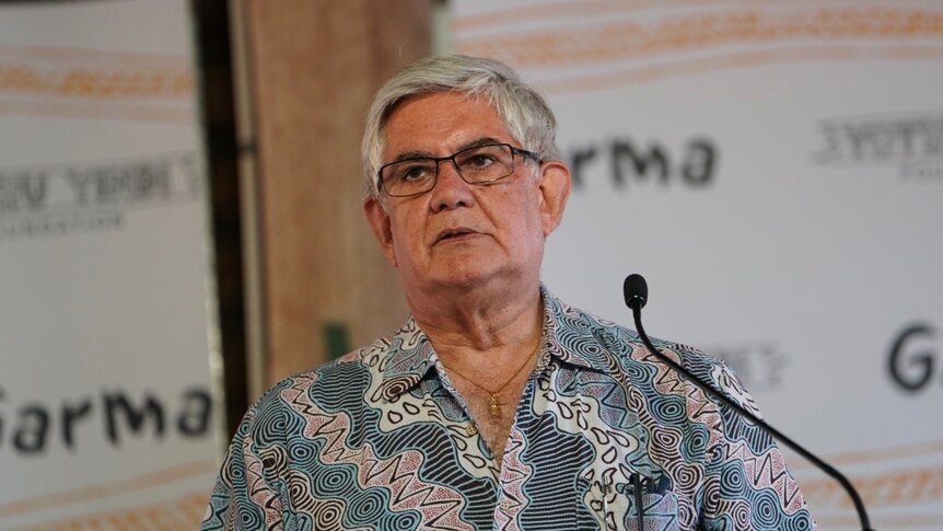 Ken Wyatt, wearing a collared shirt with what appear to be Indigenous designs in blue, red, and black