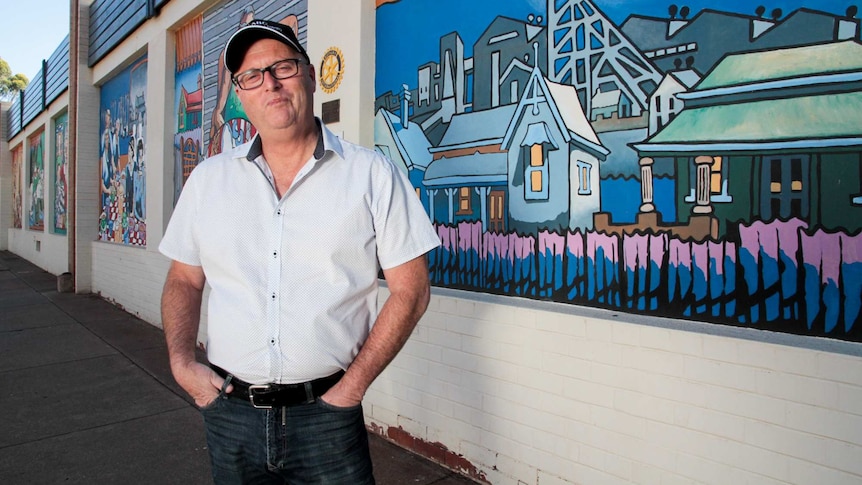 Andrew Schmidt standing in front of a street mural