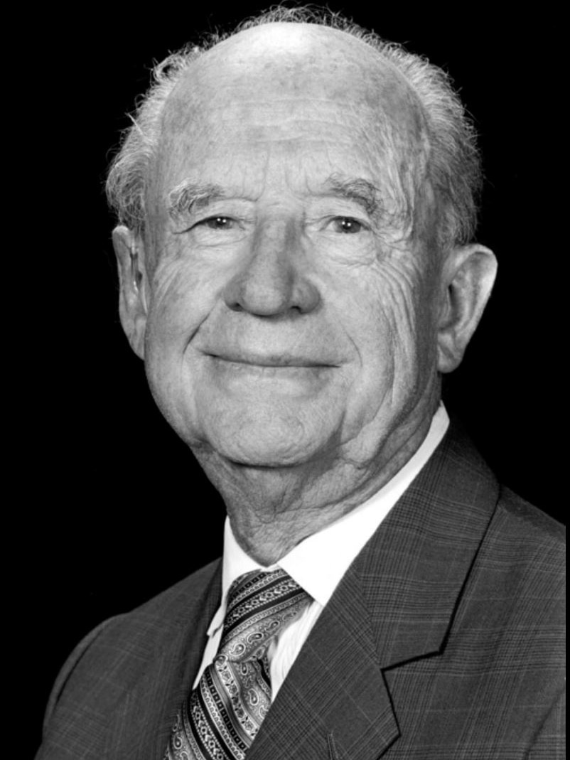 A black and white photo of an elderly man smiling.