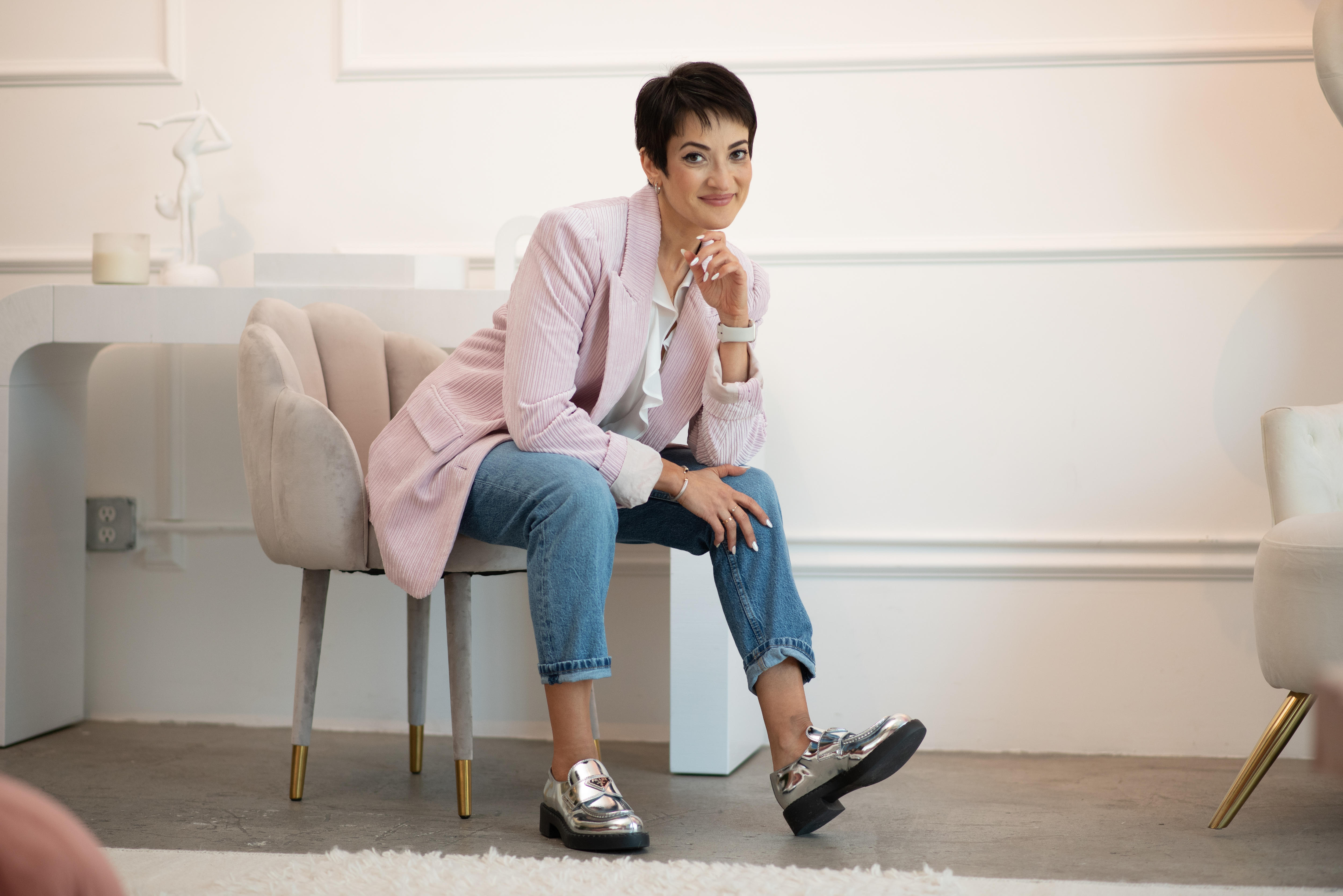 Margarit Davtian sitting on a chair with one leg kicked out