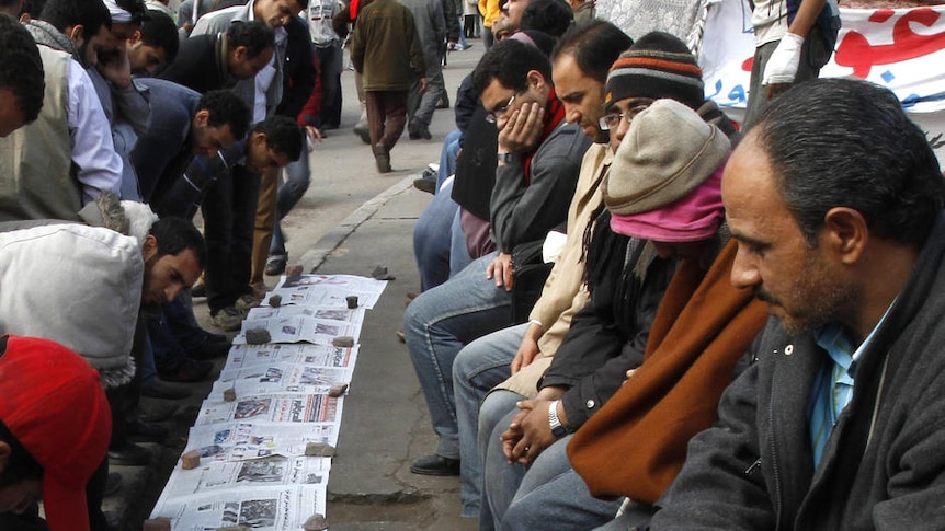 Egyptians read newsapers in Cairo's Tahrir Square as a semblance of normal life returned to the capital