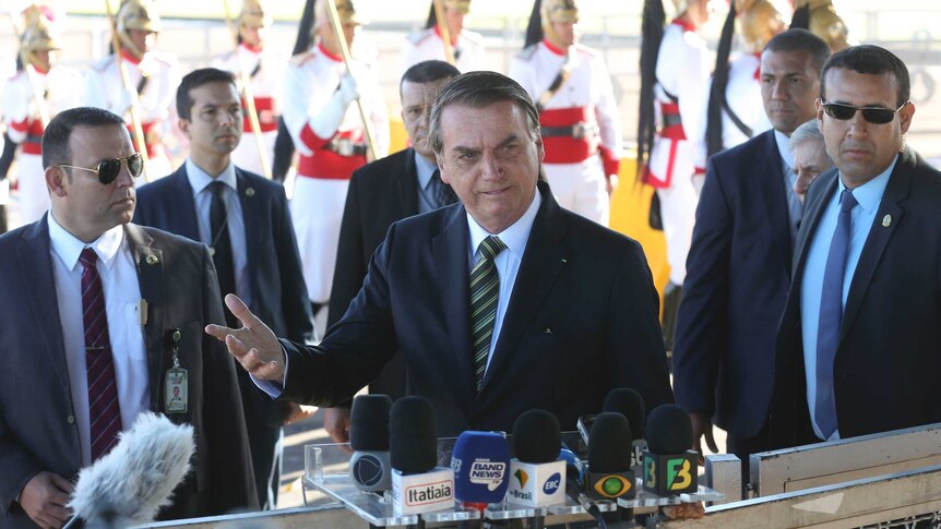 Brazil's President Jair Bolsonaro during a press conference with body guards surrounding him