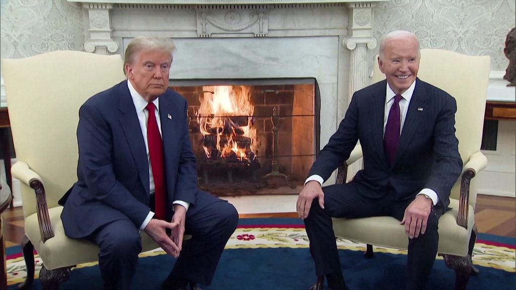 Donald Trump and Joe Biden seated in arm chairs next to a wood fire in the White House's Oval Office.