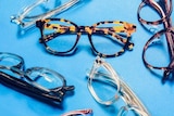 Six pairs of Oscar Wylee glasses on a blue background