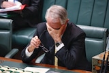 Prime Minister Malcolm Turnbull with his head in his hands