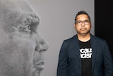The Aboriginal Australian artist Vernon Ah Kee standing in front of one of his large scale drawings