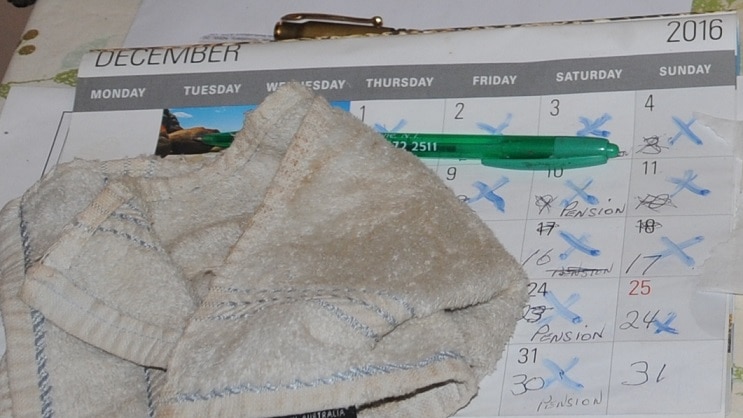 A calendar with dates crossed off and a rag lying on top.