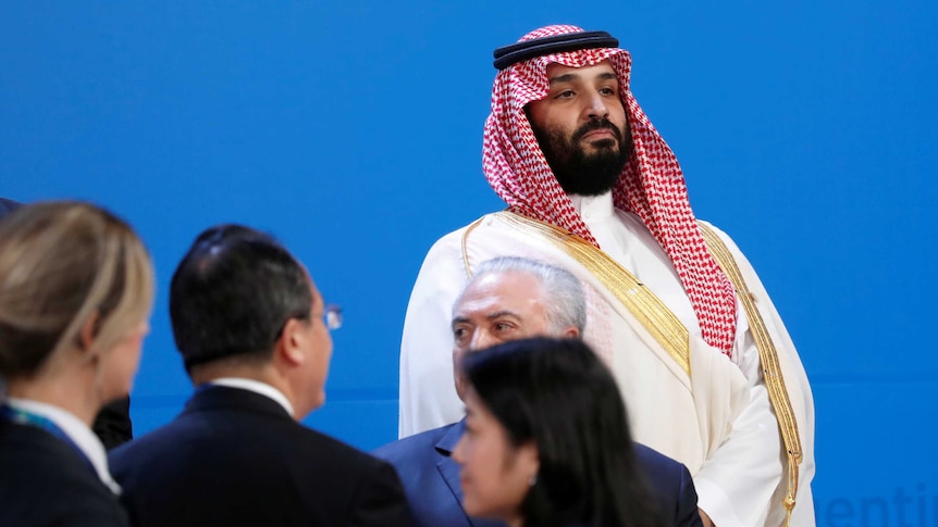 Mohammed bin Salman watches on as world leaders arrive before the family photo is taken at the G20 Summit.