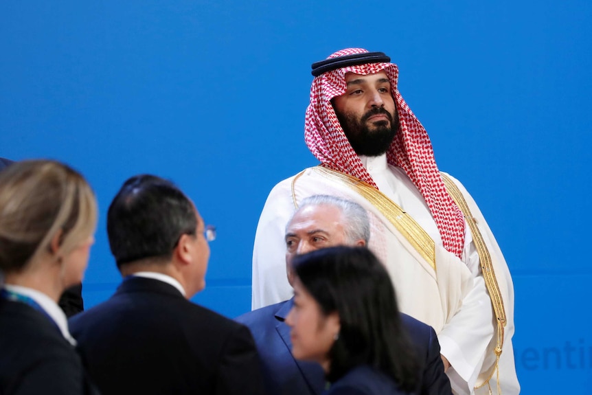 Mohammed bin Salman watches on as world leaders arrive before the family photo is taken at the G20 Summit.