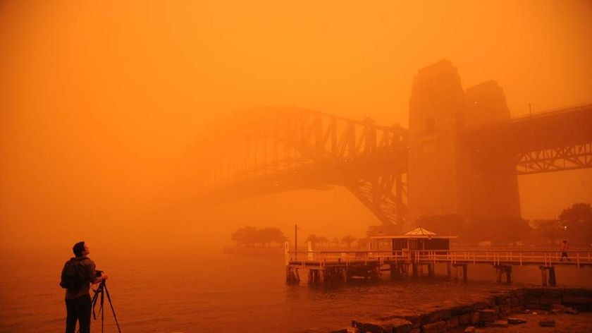 Red haze envelopes Sydney Harbour Bridge.