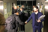 AFP officers, lawyers and ABC staff shake hands after the raids.