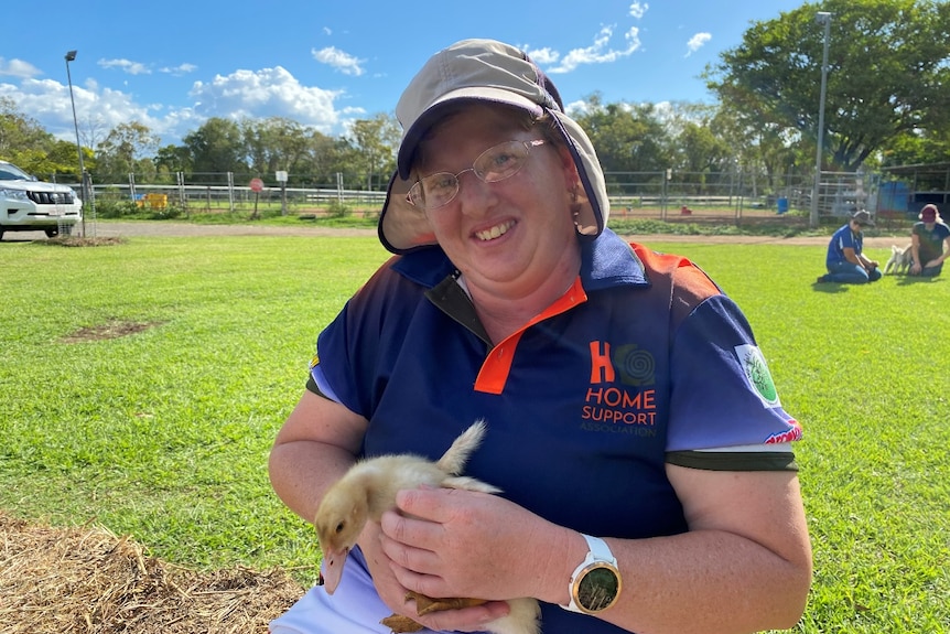 Woman holding a duckling on a farm