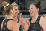 A group of Giants Super Netball players congratulate each other.