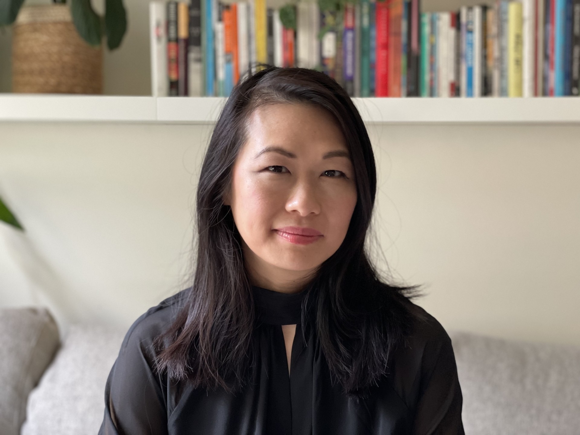 A woman in a black shirt smiles.