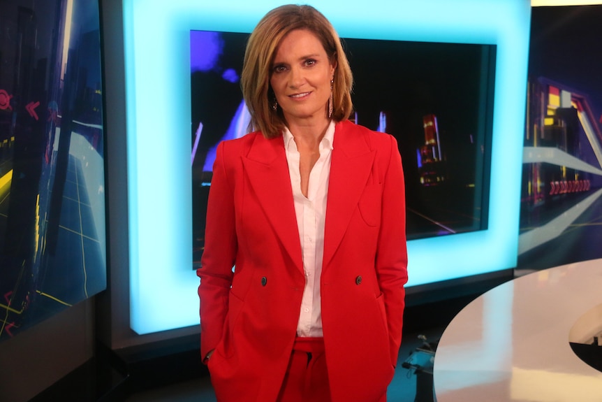A woman in a red jacket on the set of The Drum.