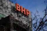 A close up of orange letters that read "BHP" affixed to the side of a building.