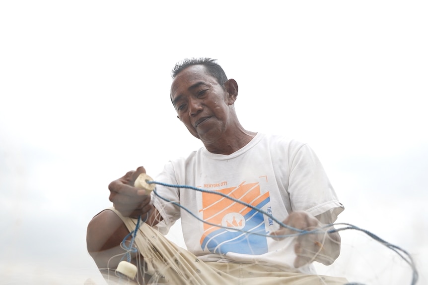 An Indonesian fisherman checks nets.