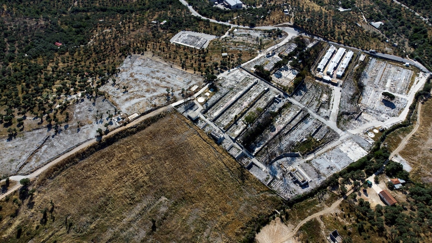 An aerial view of the destroyed Moria camp shows a burnt out patchwork of former dwellings.