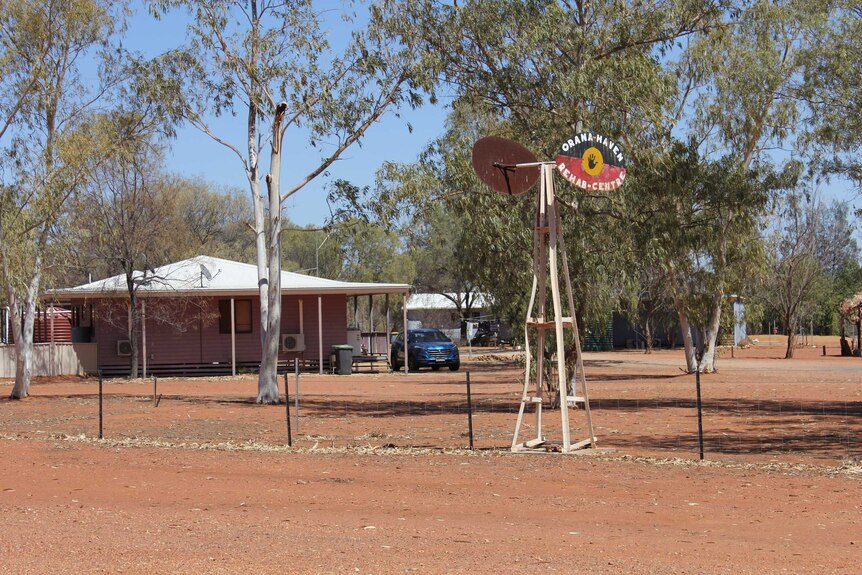 A small building set against an arid outback landscape with a rustic sign saying Orana Haven Rehab Centre.