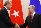 Russian President Vladimir Putin and Turkish President Recep Tayyip Erdogan shake hands.