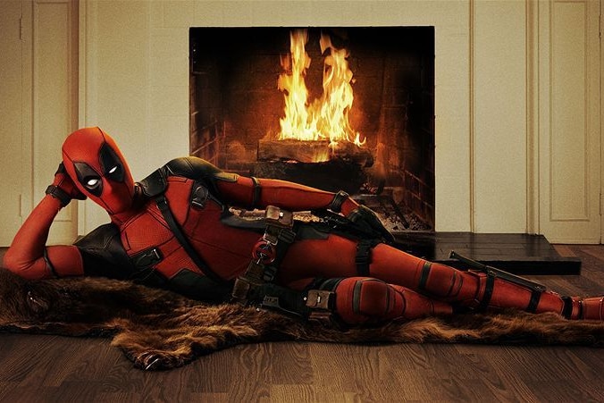 The cartoon character Deadpool lies next to a fireplace.