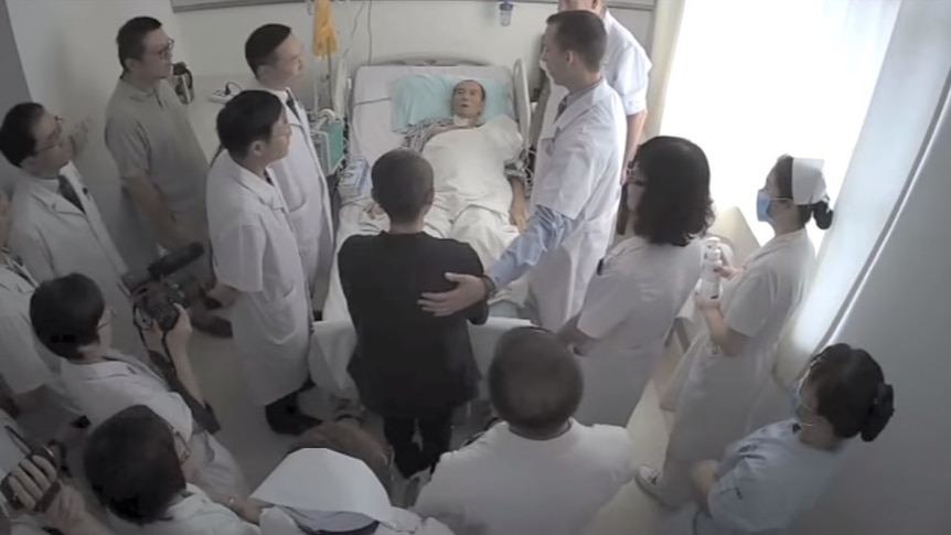 Fourteen foreign medics surround Liu Xiaobo as he lies in a hospital bed.