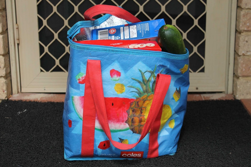 colourful bag with groceries inside left on doorstep