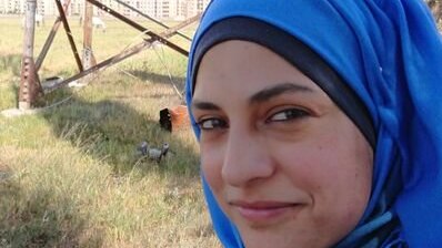 Marwa Al Sabouni wears a blue headscarf and smiles at the camera