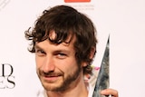 Gotye poses for photos with one of his four ARIA awards.