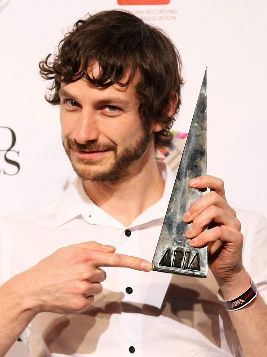 Gotye poses for photos with one of his four ARIA awards.