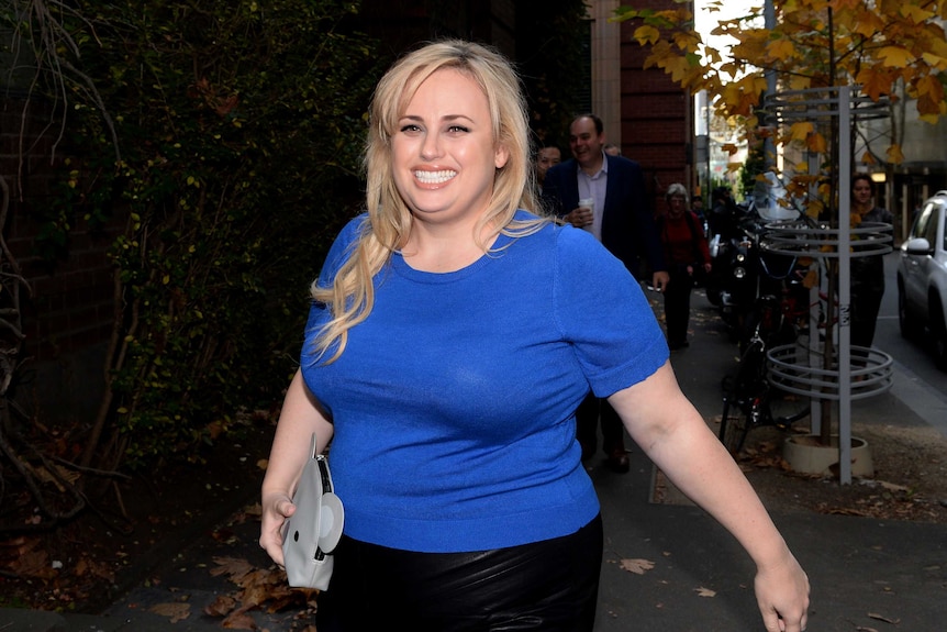 Rebel Wilson smiles as she walks to court