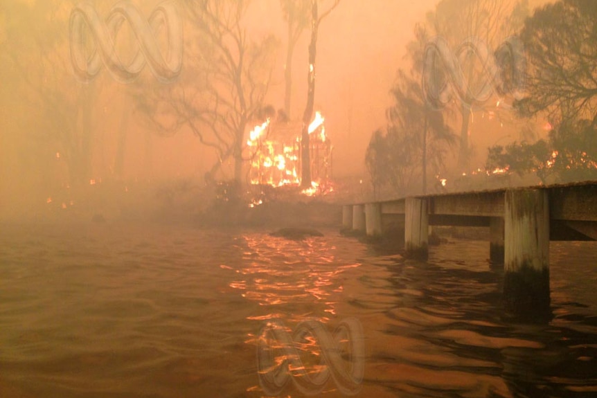 A bushfire encroaches on the waterfront at Dunalley.