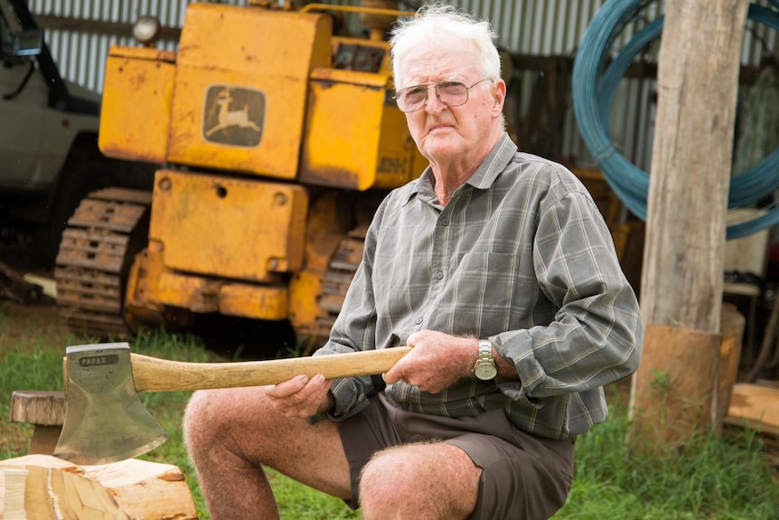 Martin Conole sits on a wooden stool after demonstrating his axe wielding skills.