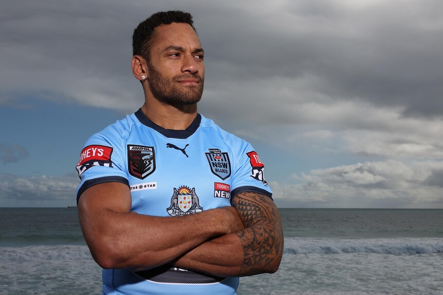 Apisai Koroisau poses for a photo at the beach in his Blues kit