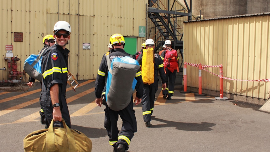 fire fighters carrying heavy bags up stairs
