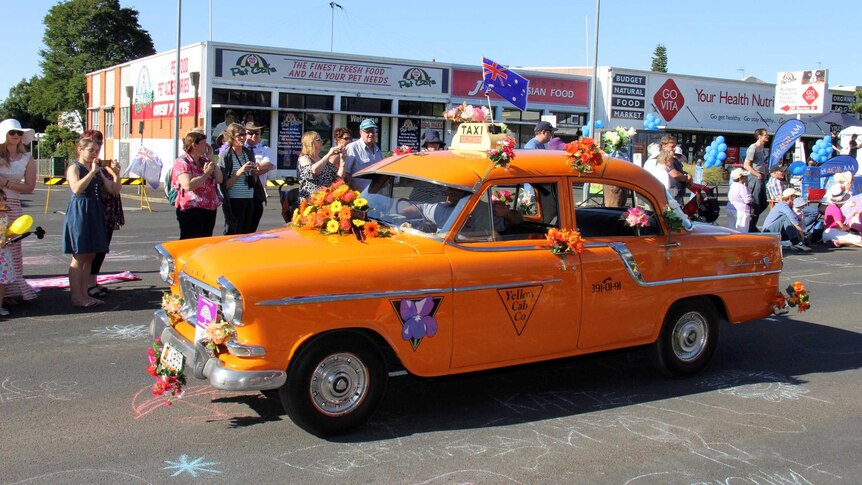 An old Yellow Cab drives during the parade at the Carnival of Flowers.