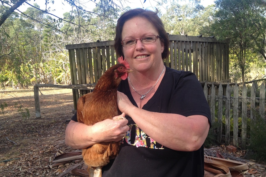 Lee McCosker holding a red chicken.