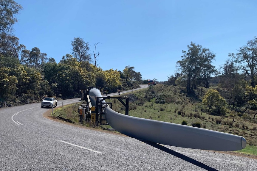 An 80-metre-long wind turbine blade was left across the road after the truck rollled.