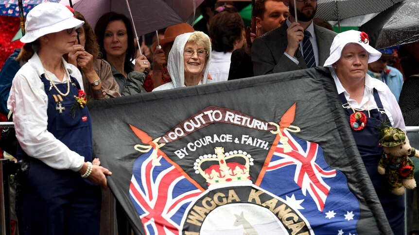 Two women hold a banner at the Remembrance Day Service at the Cenotaph in Martin Place, Sydney.